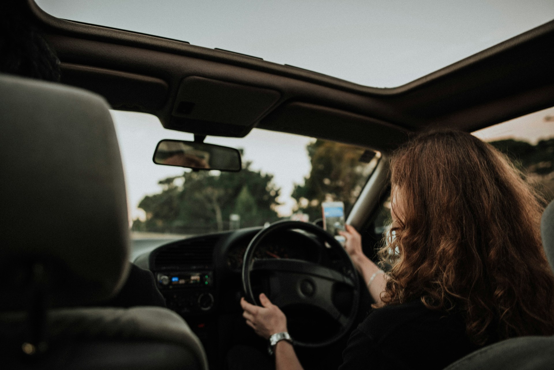 A woman taking a selfie while driving