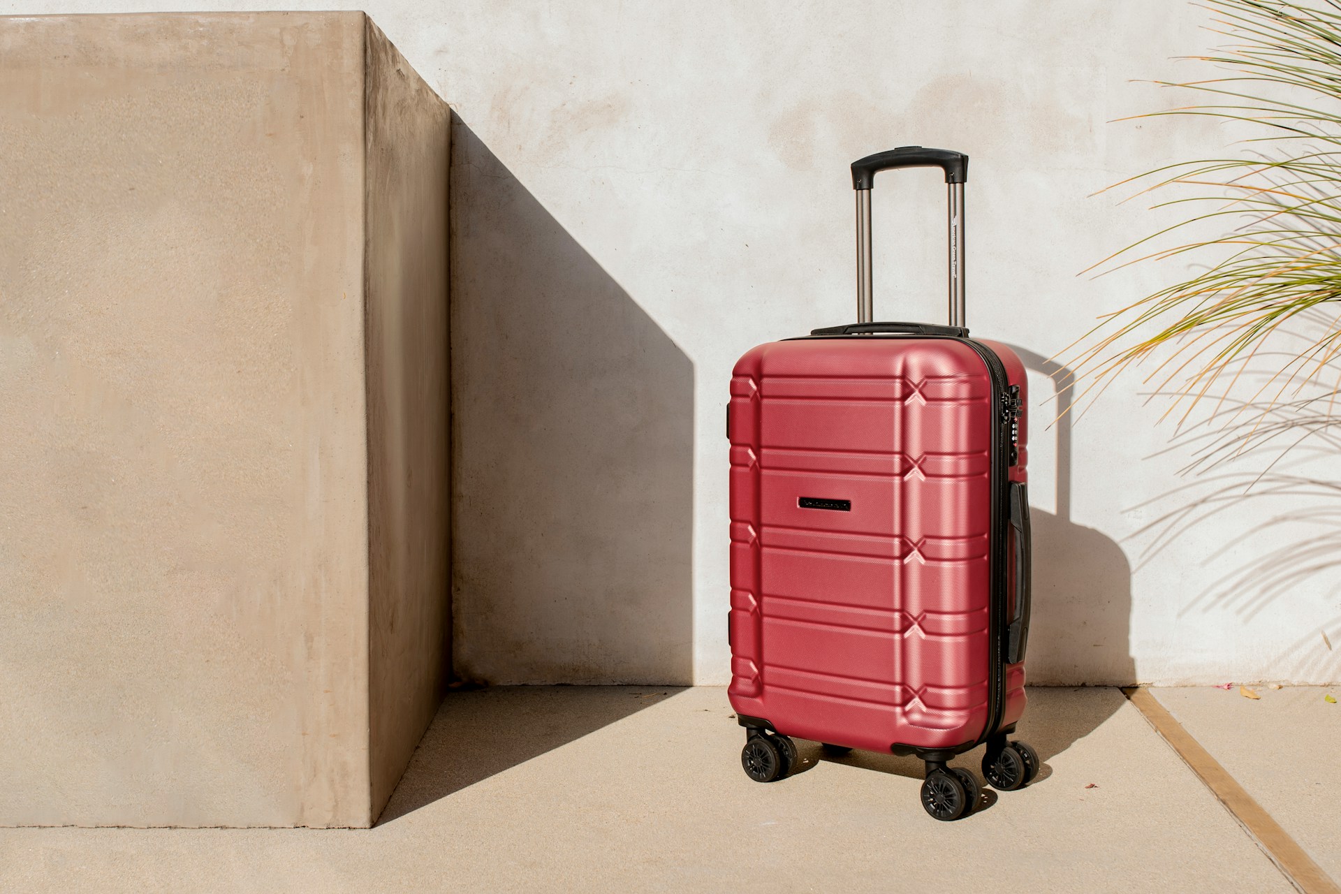 A red suitcase against a wall