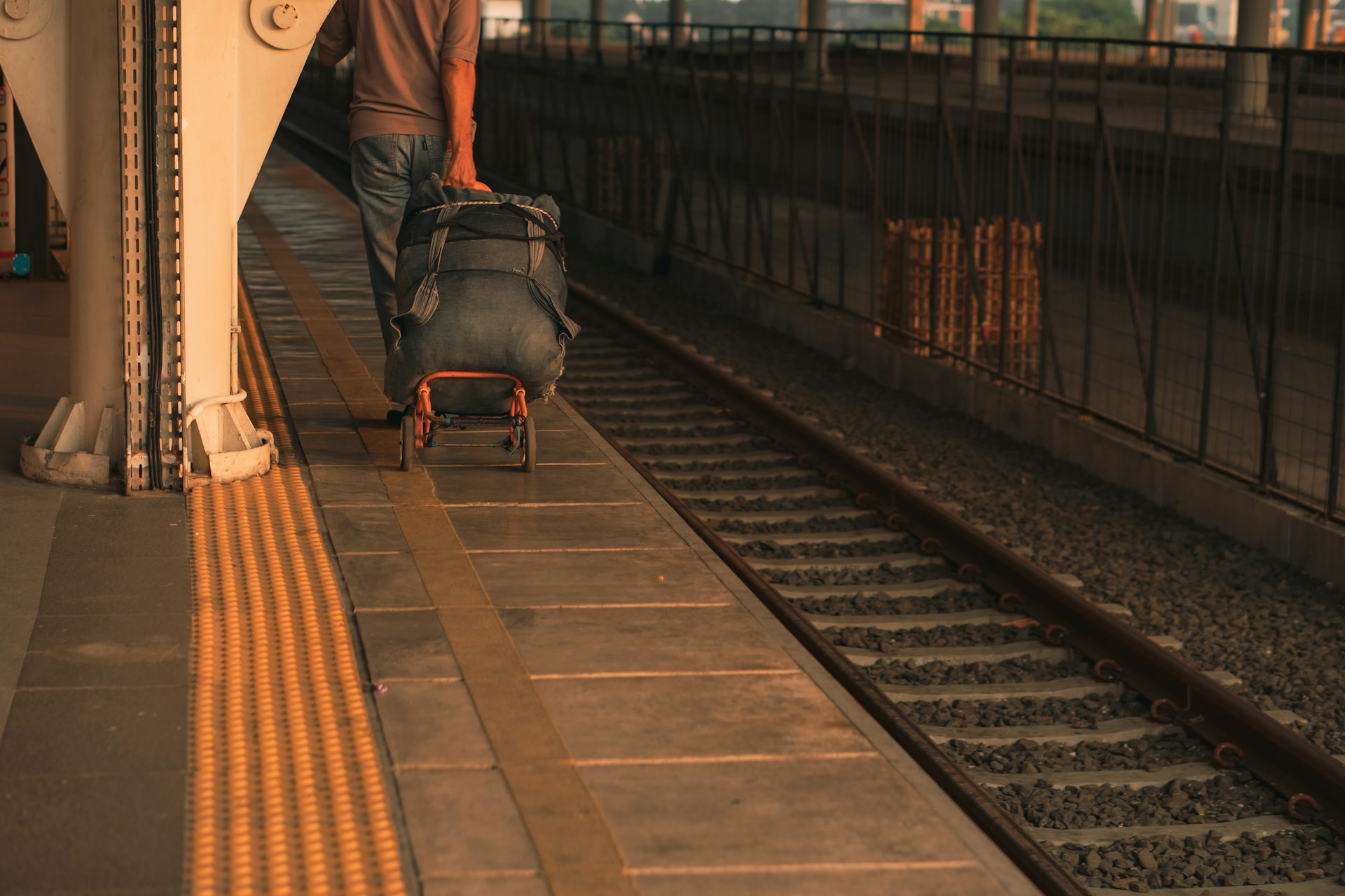 person pulling suitcase along train platform