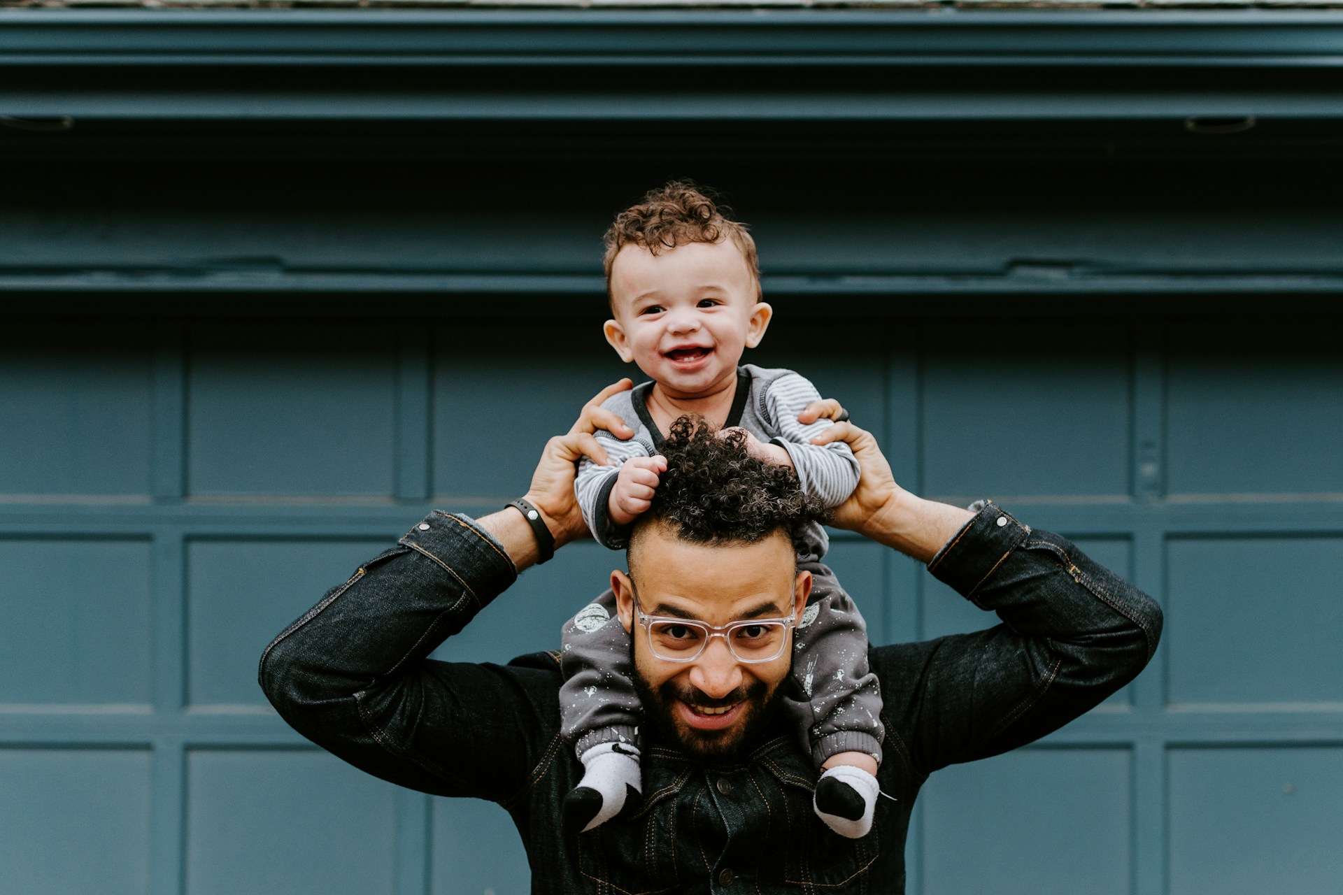 A man carrying a baby on his shoulders