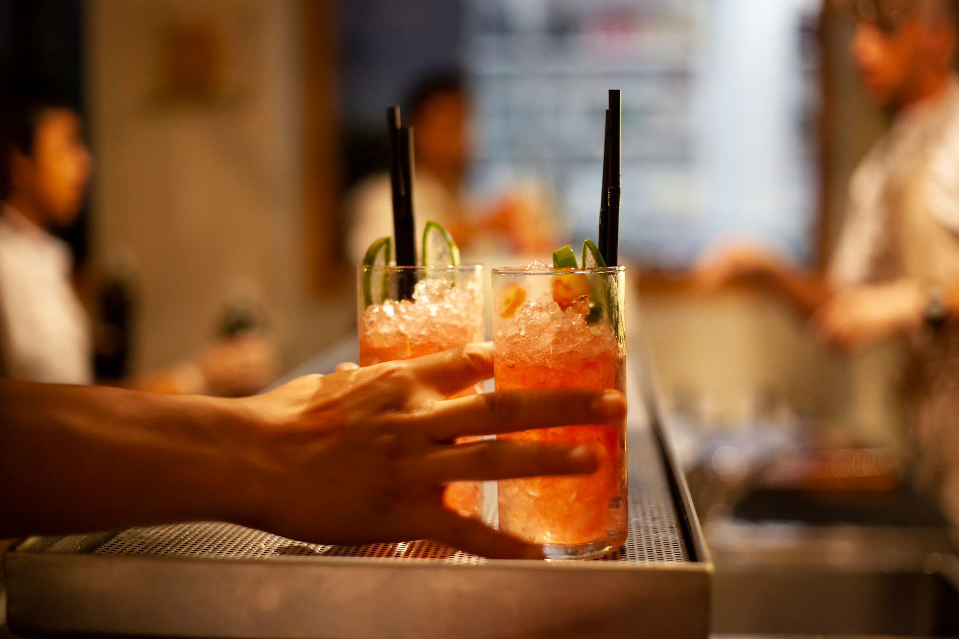 Person holding iced drinks in an upscale restaurant