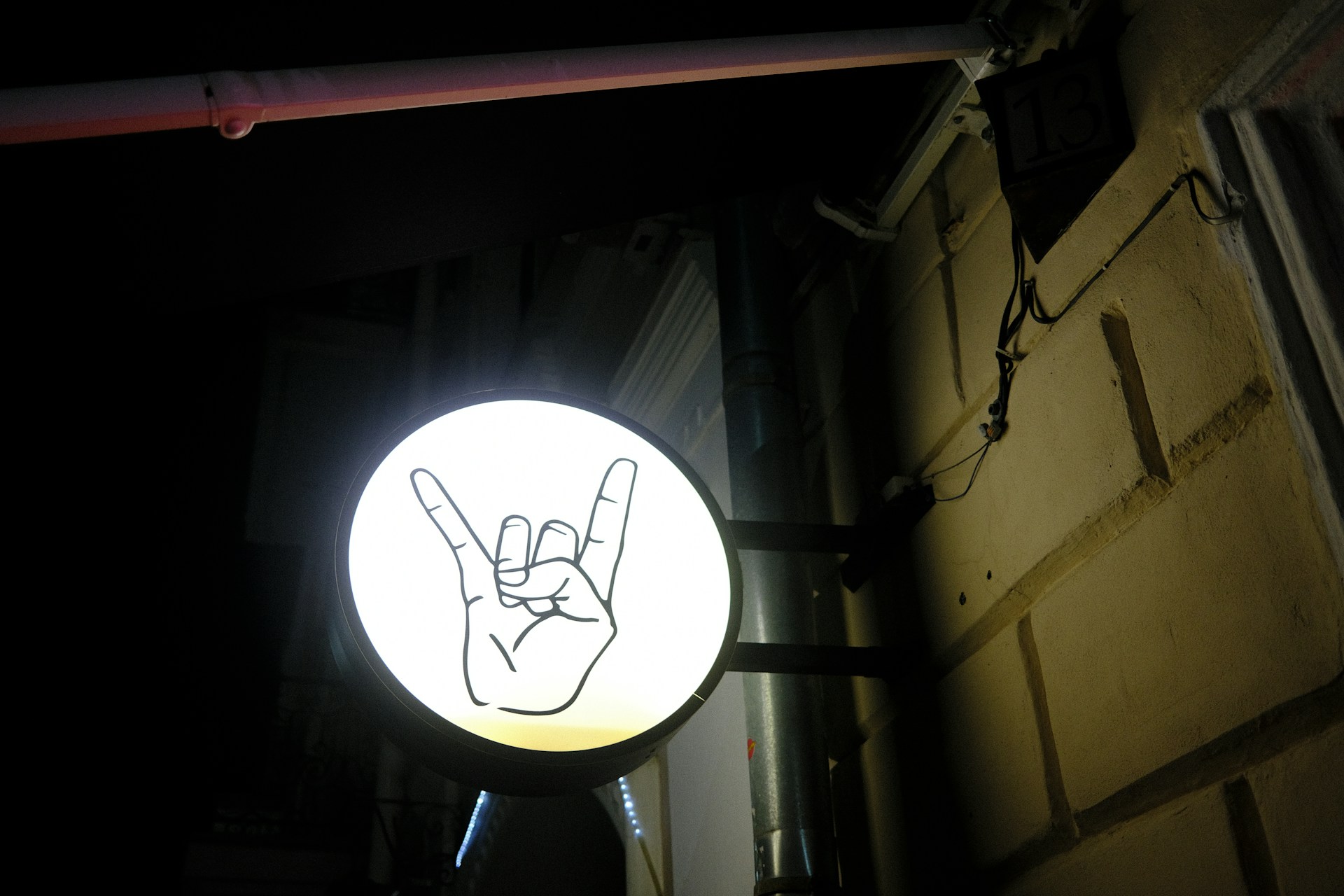 A neon sign showing the horn rocker hand gesture