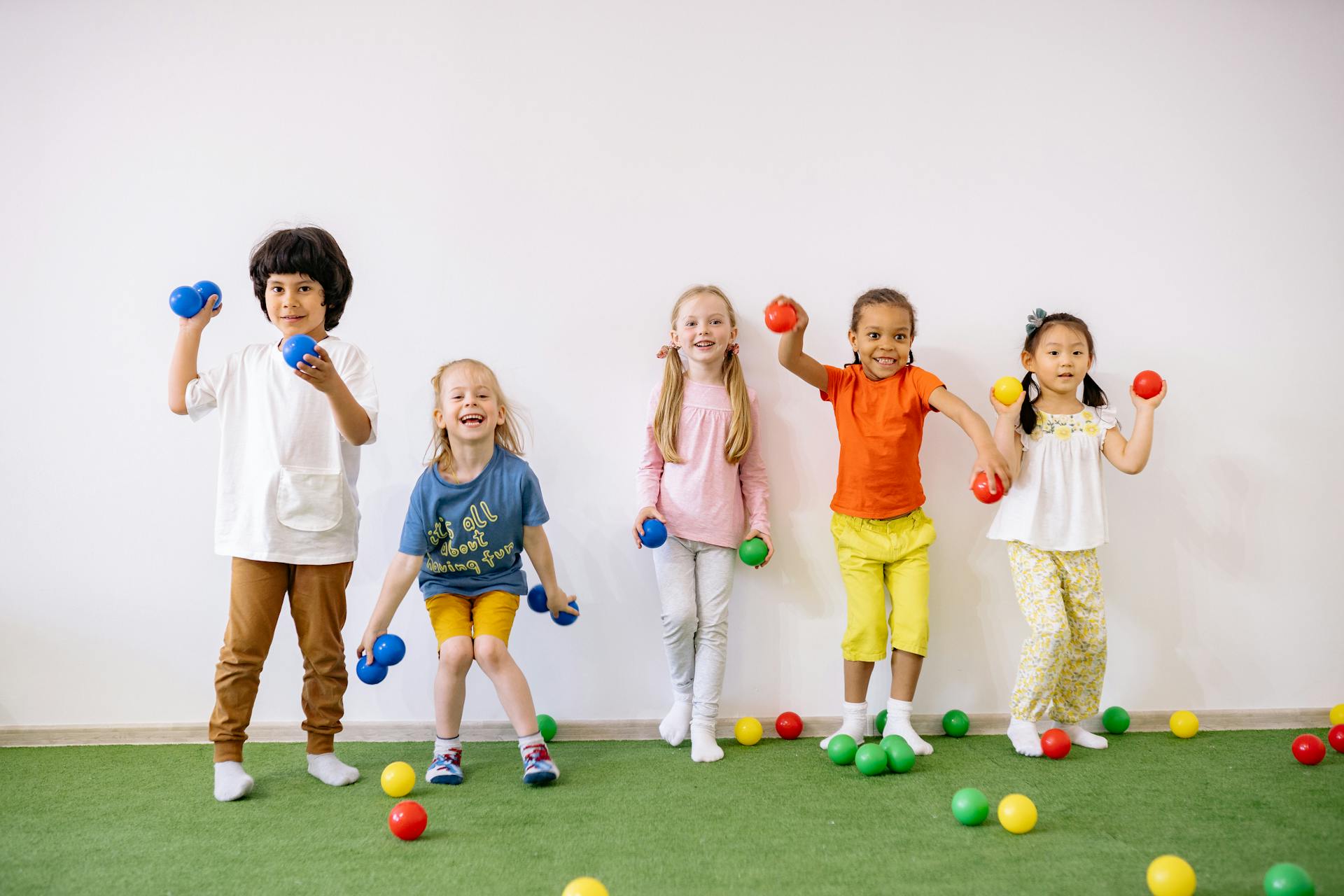 Girls and boys playing with colorful balls
