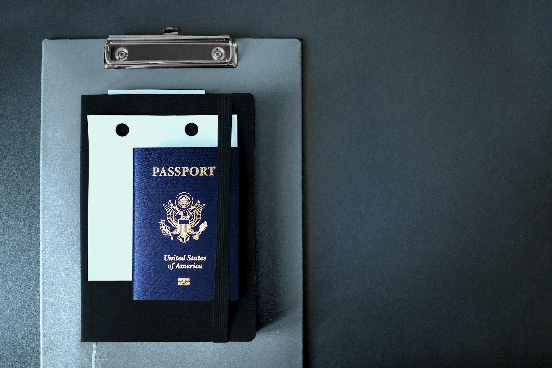american passport atop clipboard with forms