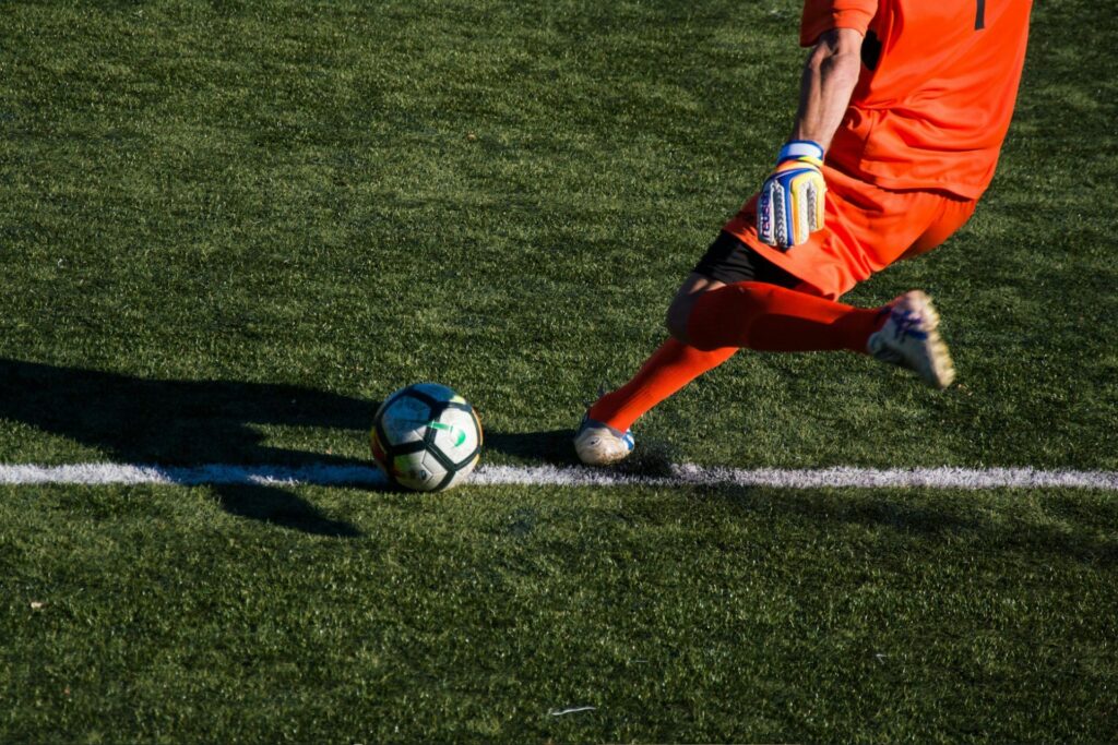 A goalkeeper taking a kick in a soccer game