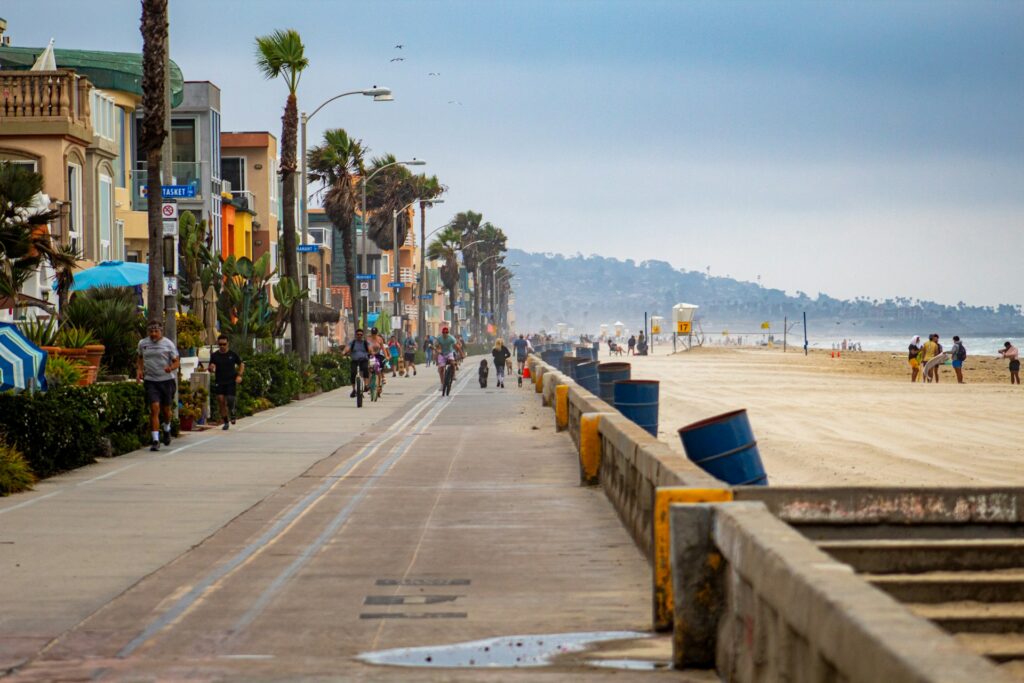 people walking on a beachfront sidewalk in daytime