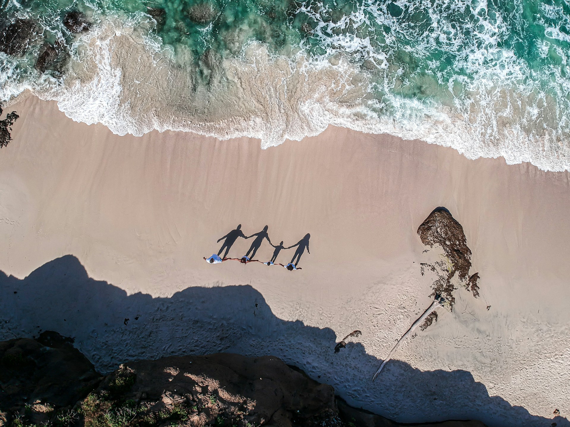 A family holding hands on a beach