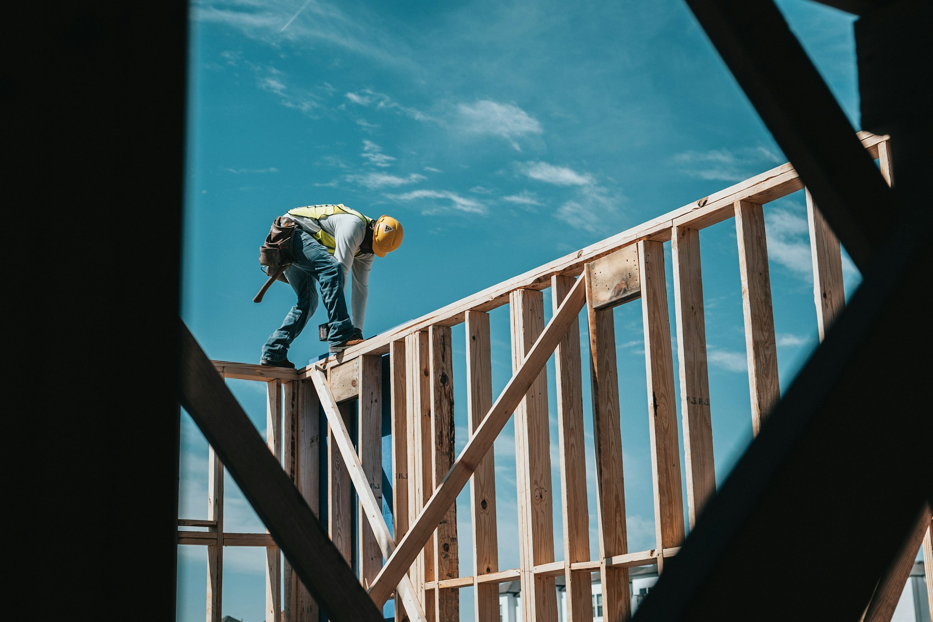 A construction worker walking on wooden beams
